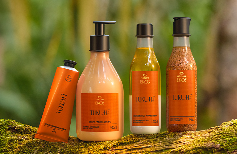 Kit de productos Ekos Tukuma colocados sobre un tronco en la selva amazónica de Brasil.