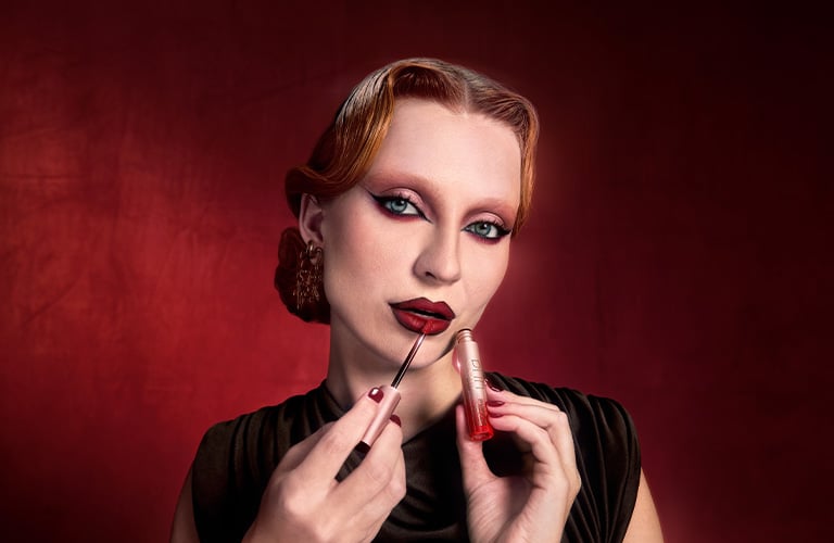 Mujer finalizando su maquillaje de Halloween con un labial rojo