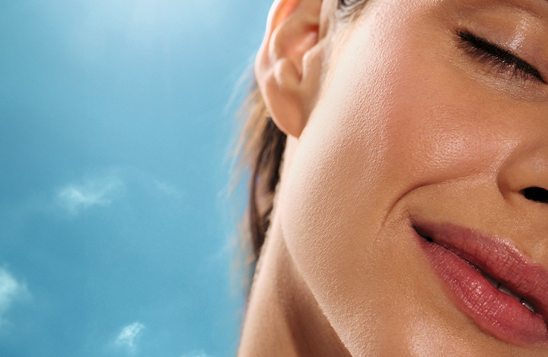 Close up de modelo de ojos cerrados en la playa