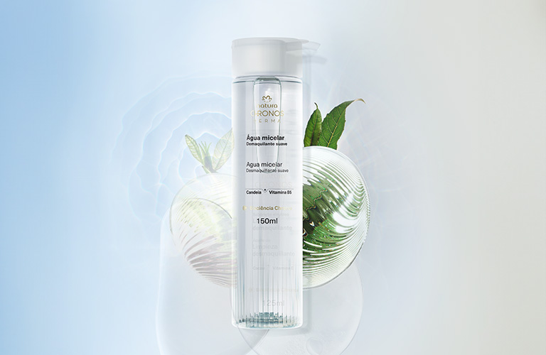 Desmaquillante Intensivo Bifásico Chronos sobre un fondo texturizado y una gota de producto detrás de él.