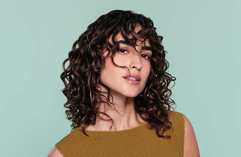 Máscara Concentrada Nutritiva Tododia durazno y almendra con un fondo de colores y una gota del producto esparcida.