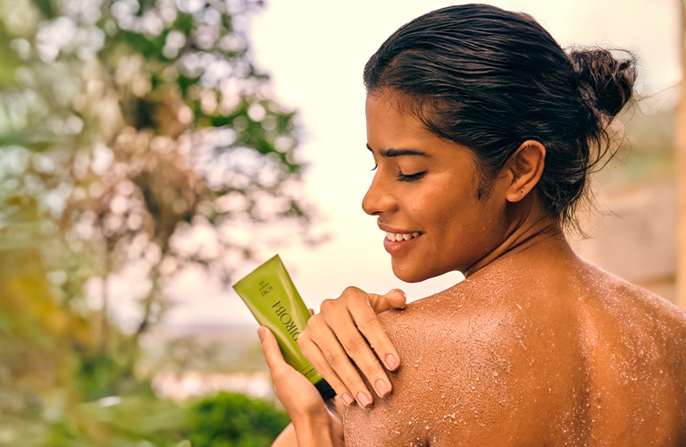 Mujer colocándose jabón en barra Ekos Andiroba.