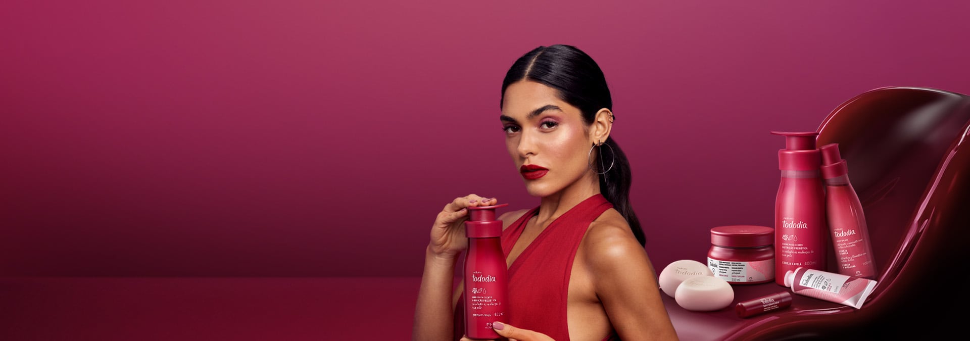 Fondo rosa con una crema hidratante corporal Tododia a la derecha, con la textura del producto detrás.