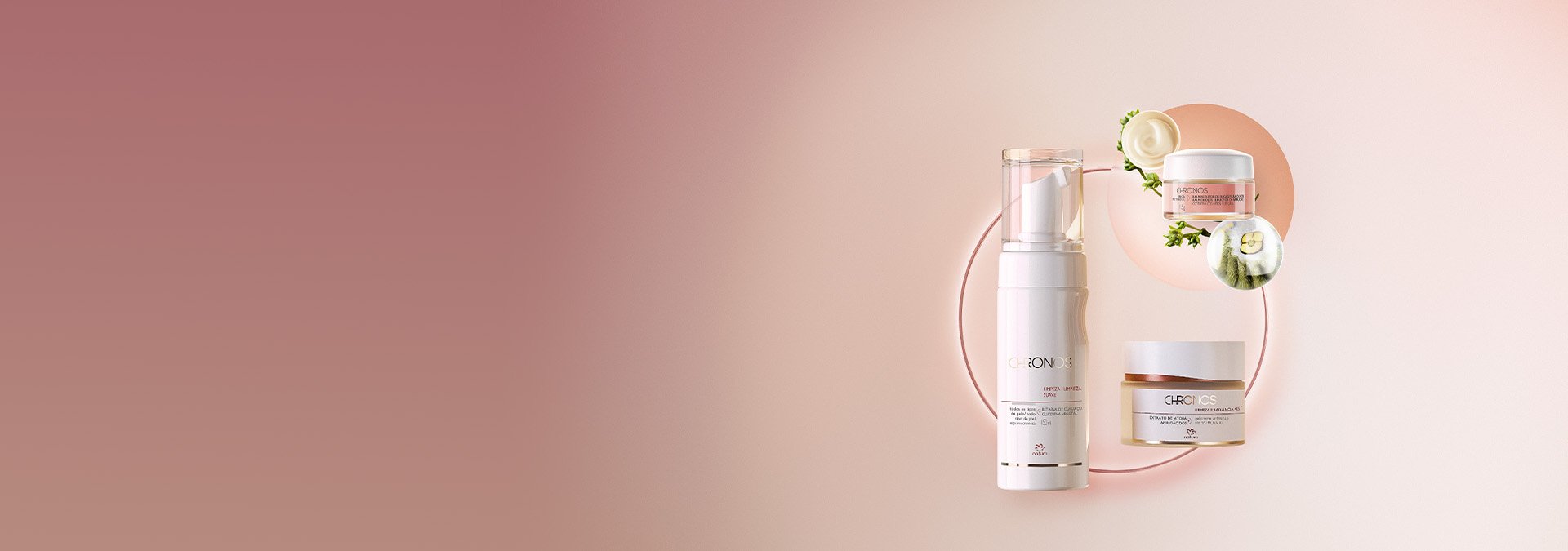 Un producto de limpieza facial, un exfoliante y una crema hidratante para el rostro. Todos Natura Chronos sobre un fondo rosa pastel.