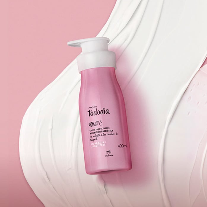 Imagen con una textura de crema sobre un telar color rosa fondo nuestra crema tododia de frutos rojos al frente