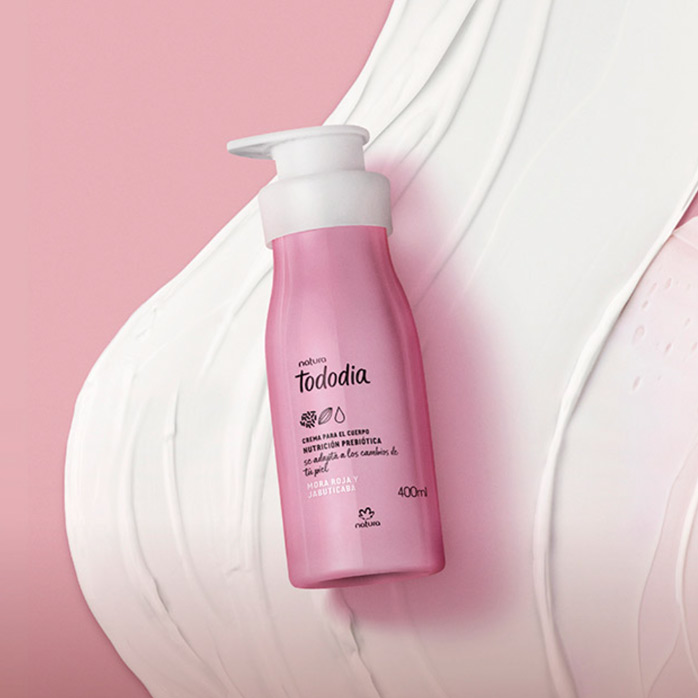 Imagen con una textura de crema sobre un telar color rosa fondo nuestra crema tododia de frutos rojos al frente